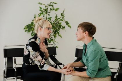 Duas mulheres sentadas conversam em um ambiente interno, em uma interação de apoio e acolhimento.