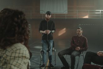 Pessoas diversas sentadas em círculo durante uma sessão de apoio e conversa sobre saúde mental.