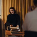 Autor conversa com o público durante encontro literário em uma livraria.