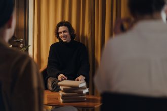 Autor conversa com o público durante encontro literário em uma livraria.